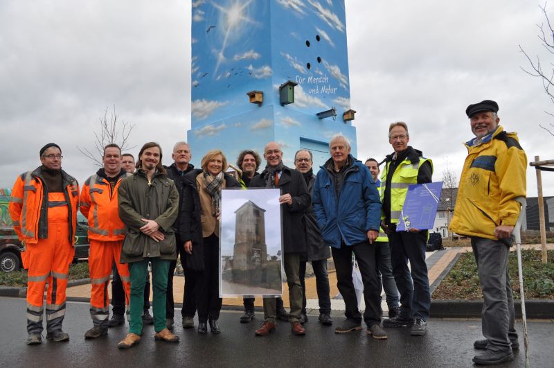 Foto zeigt Bürgermeister Bert Spilles mit den Projektbeteiligten vor dem Turm.