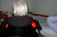 Pflegebeduerftige Person im Rollstuhl am Bett. Quelle: pixabay