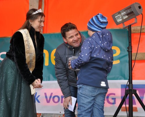 Foto zeigt Blütenkönigin, Bürgermeister und einen jungen Gewinner ser Stempelkarten-Aktion auf der Bühne.