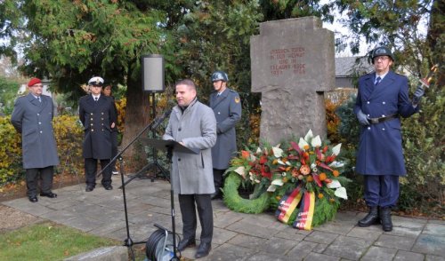 Foto zeigt Bürgermeister Holger Jung und Angehörige der Reservistenkameradschaft vor dem Ehrenmal.