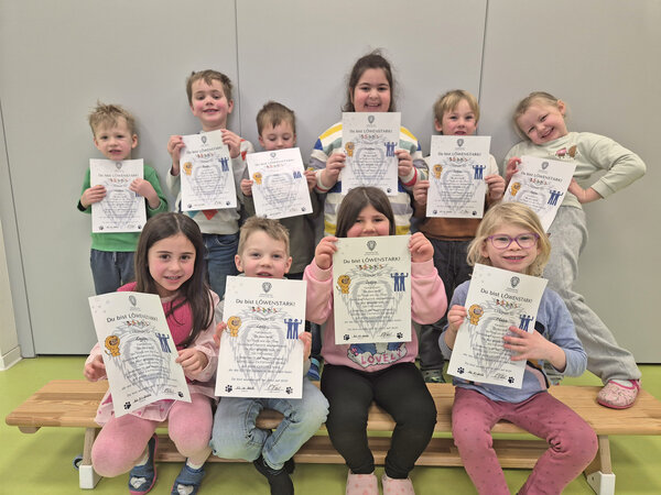 Die teilnehmenden Kinder halten die Urkunde in den Händen.