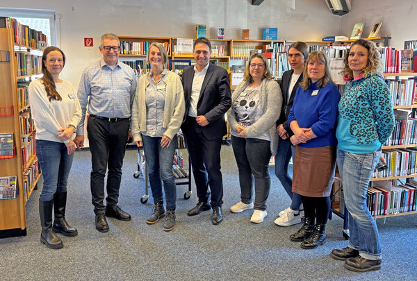 Die Beteiligten des Antrittsbesuches stehen nebeneinander im ersten Obergeschoss der Bücherei.