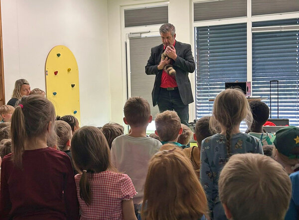 Der Zauberer steht vor den Kindern.