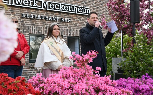 Blütenkönigin Antonia Augenstein und Bürgermeister Sven Schnieber, mit Mikro in der Hand, stehen auf der Bühne.