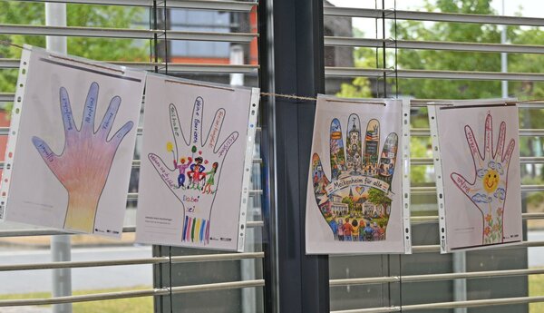 Vier Bilder hängen an der Innenseite der Fensterfront.